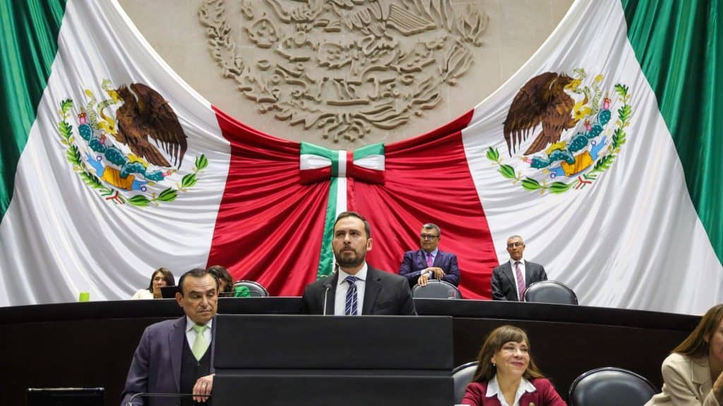Aprueban exhorto para garantizar pago a productores de trigo en Guanajuato Cámara de diputados en México con bandera mexicana gigante de fondo, política en sesión formal.