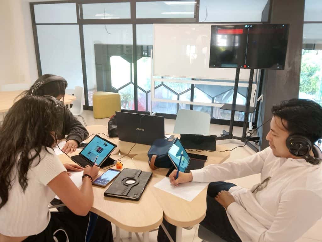 Creatividad en equipo en oficina moderna con tablets y laptops, colaboración y trabajo conjunto en ambiente innovador.