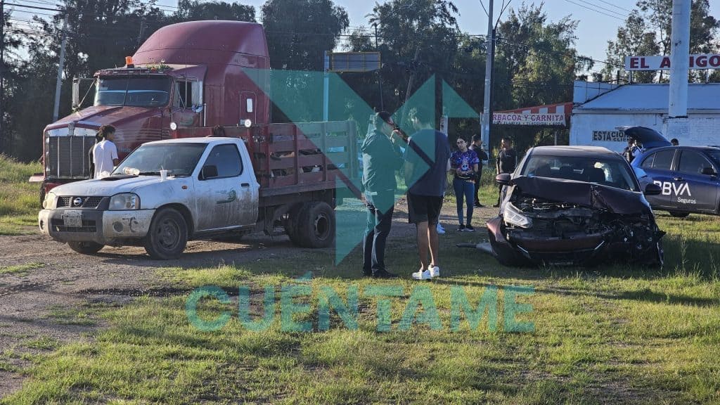 Accidente de coche y camioneta en carretera, personas observando el choque, en medio de la zona urbana.