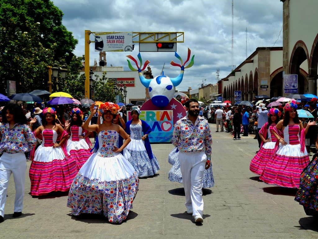 Coloresidas y tradicionales vestimentas en desfile cultural en México.