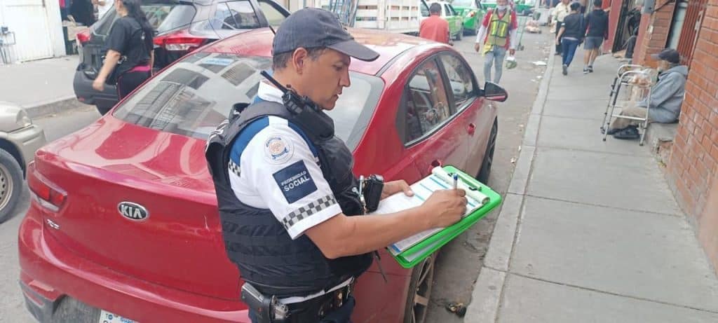 Autoridades limpian Miguel Alemán del desorden vial: 6 mil multas y 600 vehículos a pensión Policía social tomando notas en la calle, control y seguridad en zonas urbanas en México.