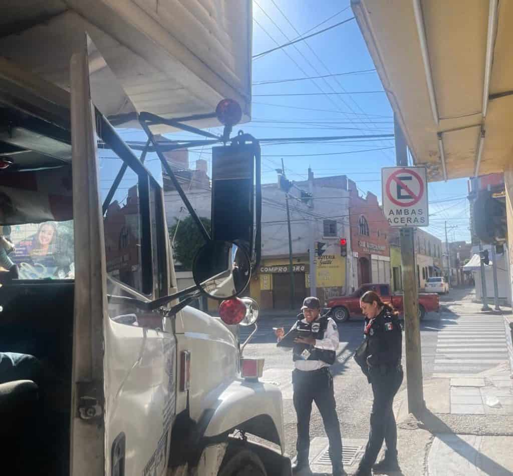 1. Policía municipal revisa permisos en calle de ciudad mexicana en día soleado.