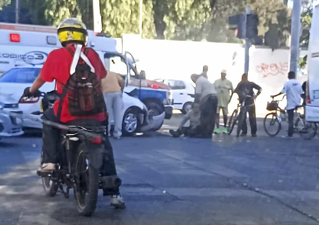 1. Persona en bicicleta en medio del tráfico, accidente vial en ciudad mexicana.
