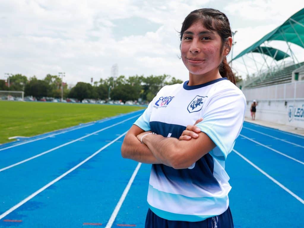 Atleta femenina en una pista de atletismo, orgullosa y segura.