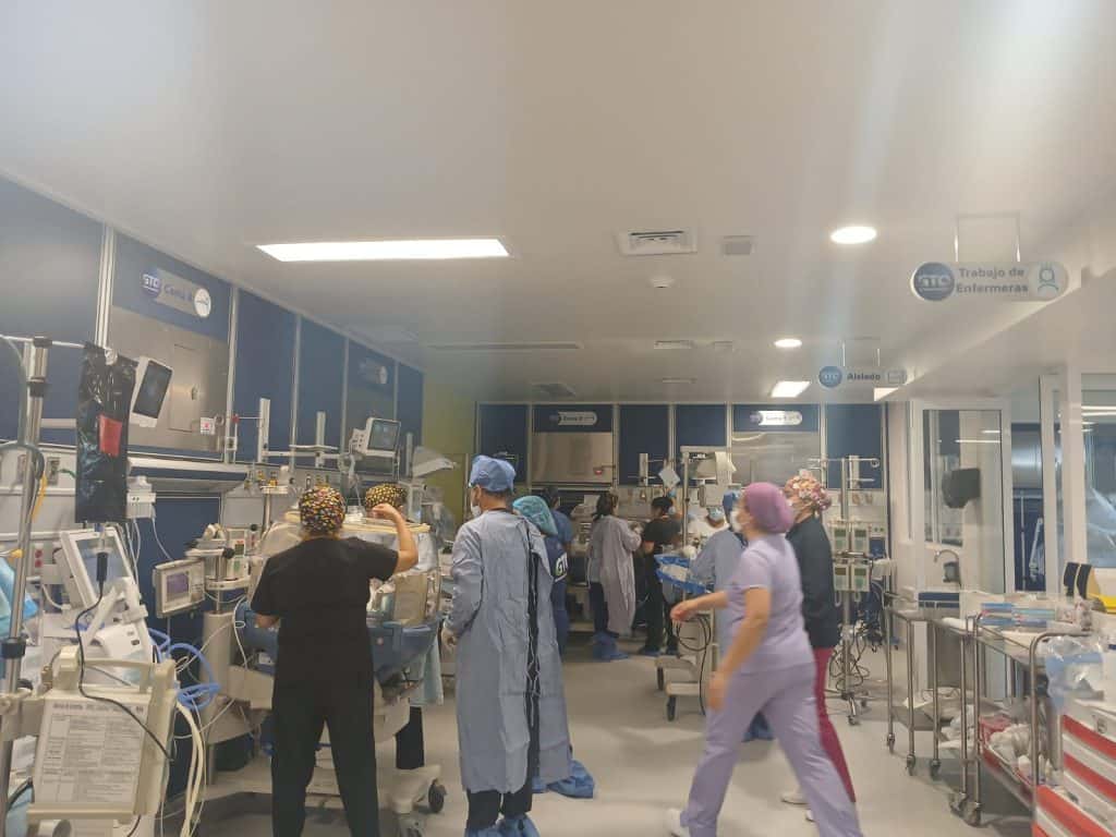 Personal de salud en una sala de hospital móvil equipado para atención médica avanzada.