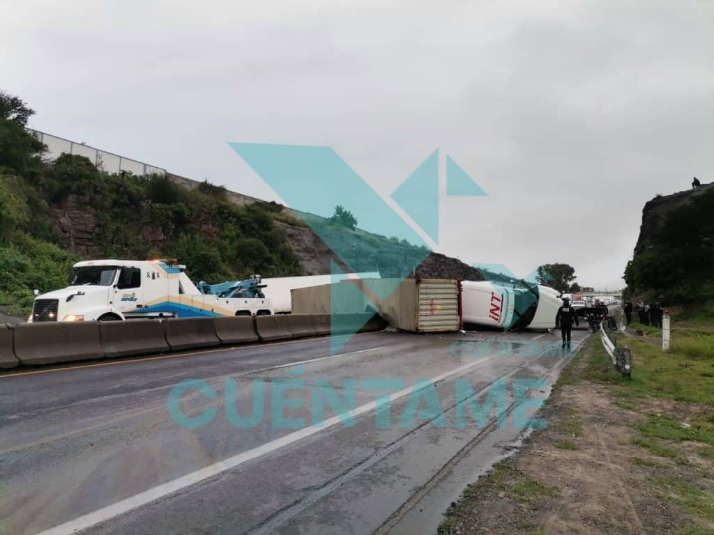 Accidente de tráiler volcado en carretera, carreteras cerradas y policía en la escena.