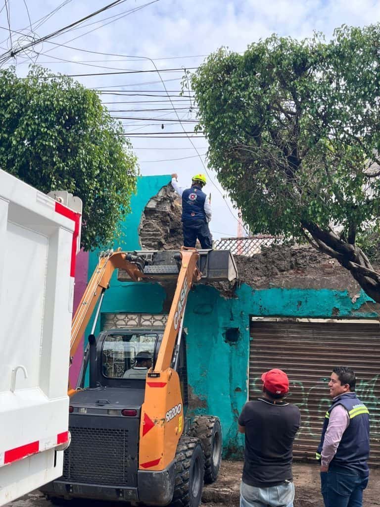 Explosión en edificio con daños estructurales en la fachada y presencia de personal de emergencia.