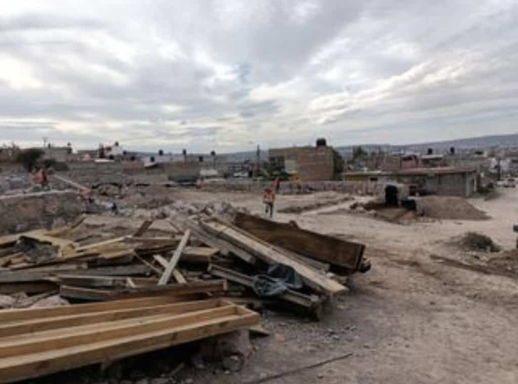 Aprueban regularización de tres colonias en León; más de 4 mil habitantes tendrán certeza jurídica y servicios básicos Montaña de madera en construcción en un techo de ciudad, industria y trabajo en progreso.