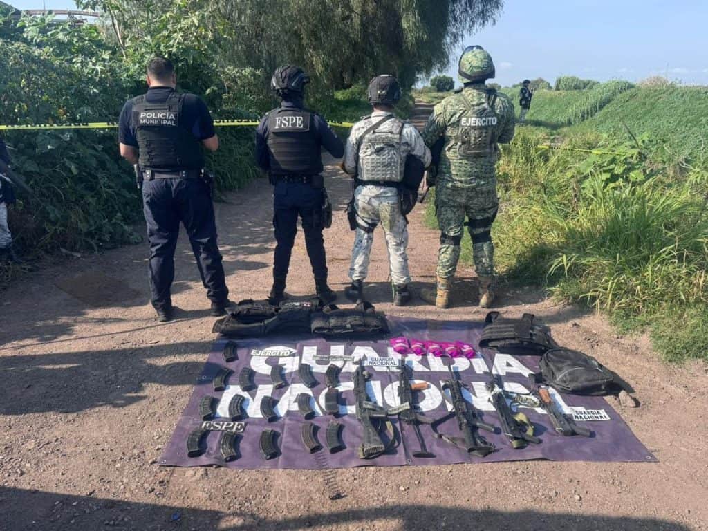 Armados y policías en operativo en zona rural con armas y equipo táctico.