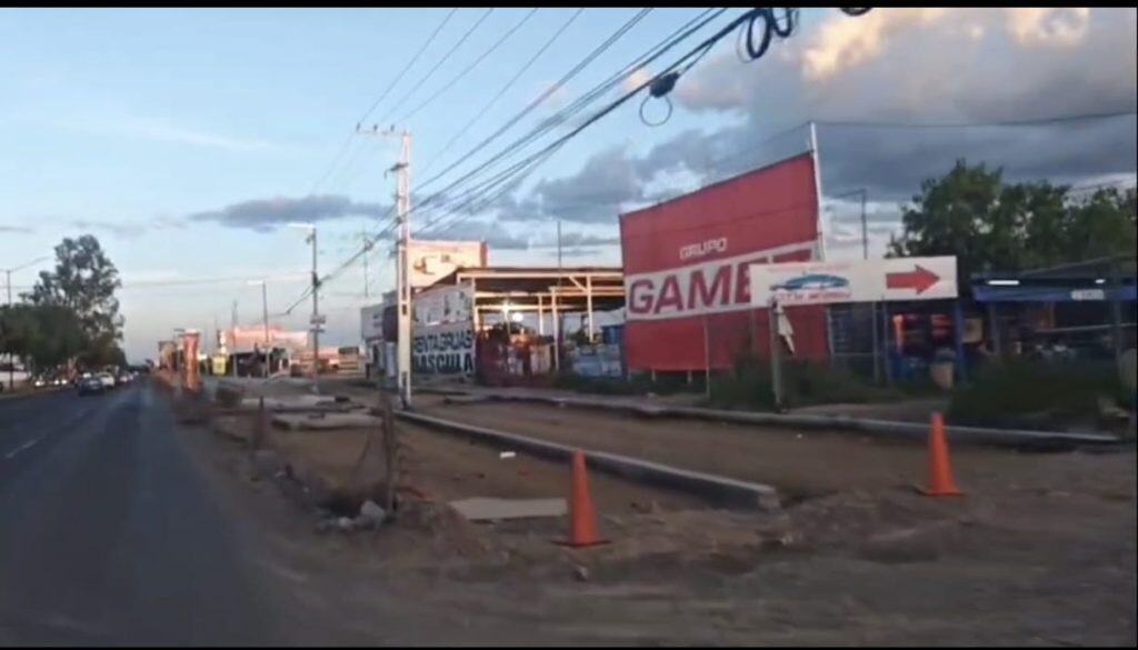 Barras de tren y comercio en la calle, en una escena urbana de México con nubes y cables eléctricos.