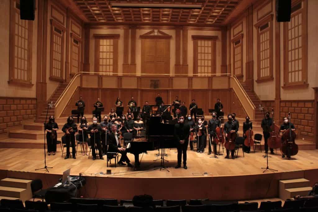 1. Sin enfoque, orquesta en escenario de concierto en sala de madera.