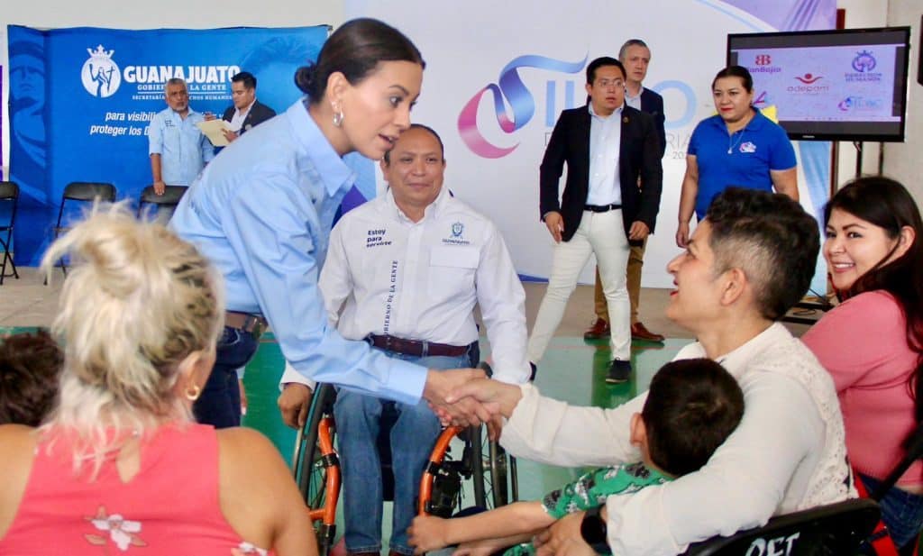 1. Funcionario del gobierno de Guanajuato saludando a una persona con discapacidad en evento oficial.
