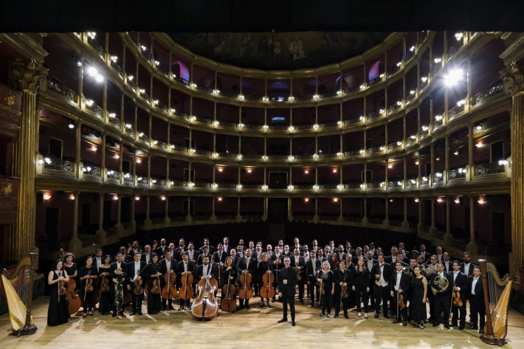 Orquesta sinfónica en concierto en teatro histórico.