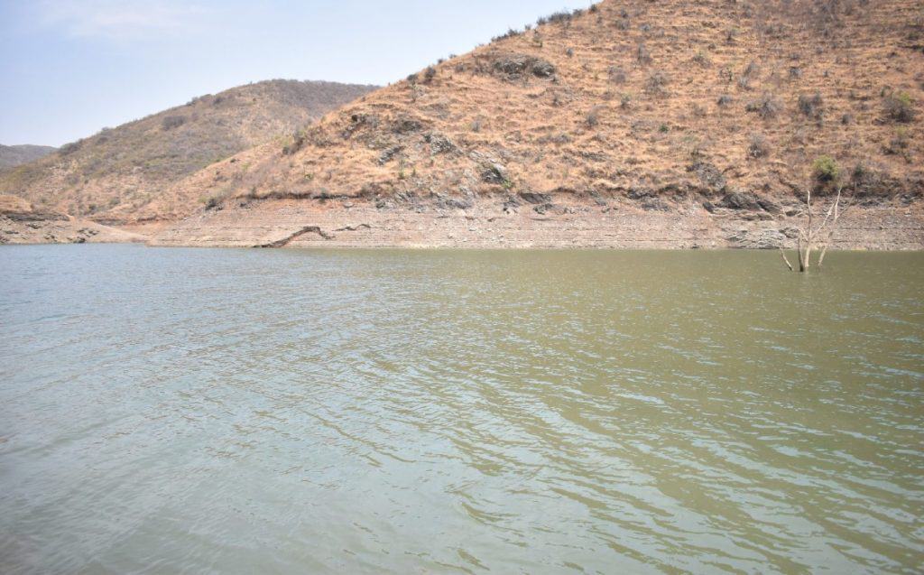 Nieve en las montañas y agua de presa en paisaje árido y seco en México.