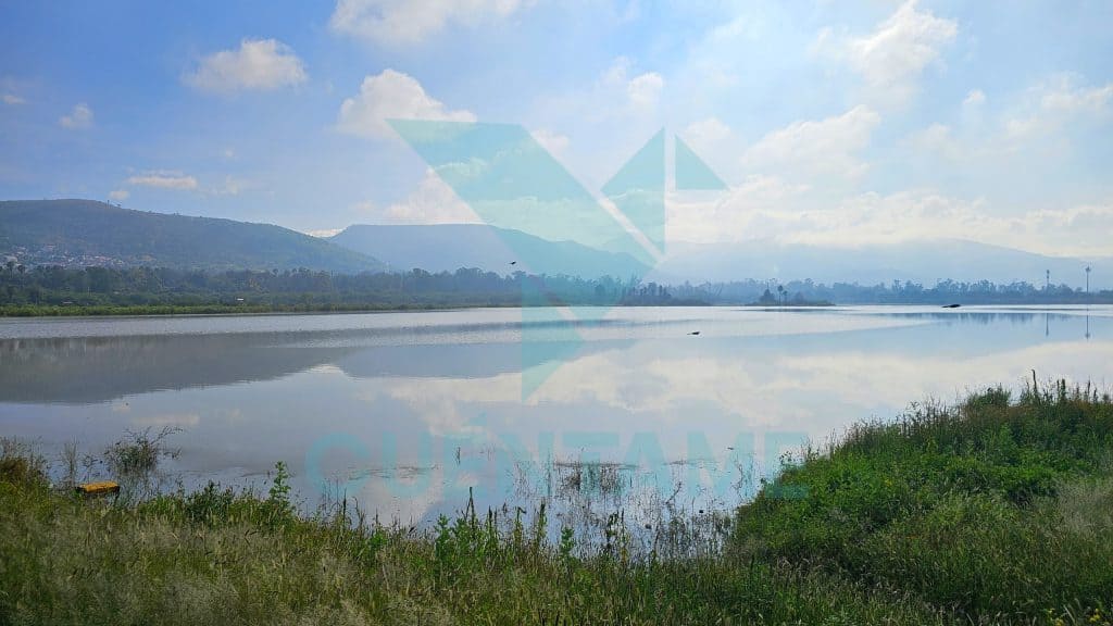 Paisaje natural con río tranquilo y montañas, ambiente sereno y agua reflectante para relajarse.