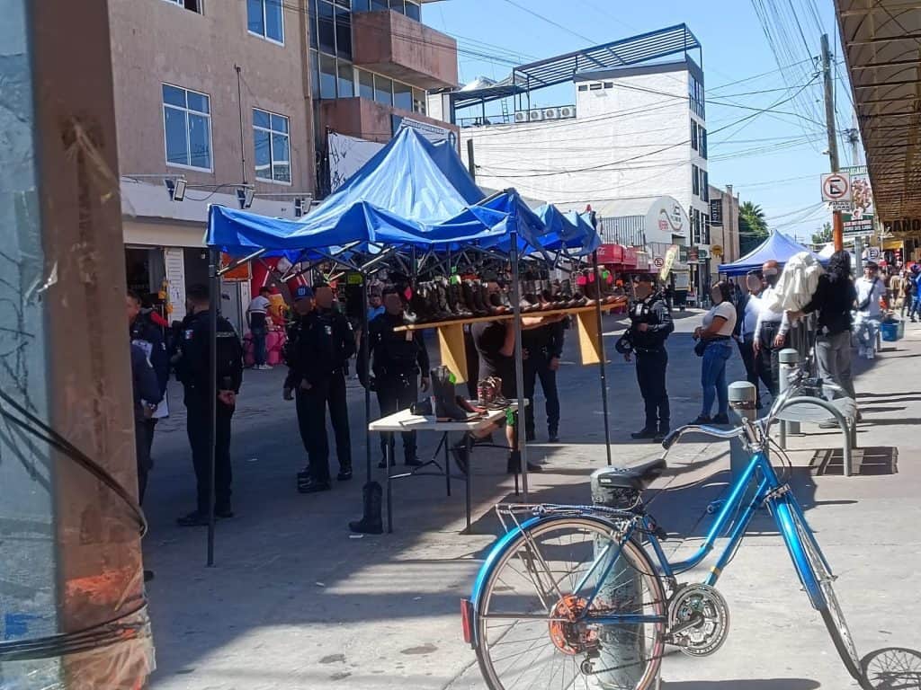 Colorido mercado al aire libre con puestos y policías en la calle, en un día soleado.