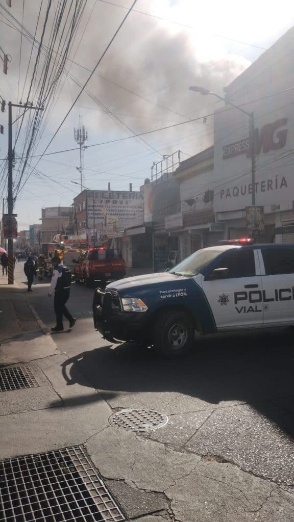Incendio en un negocio en una calle de León, con presencia de policía y bomberos atendiendo la situación.