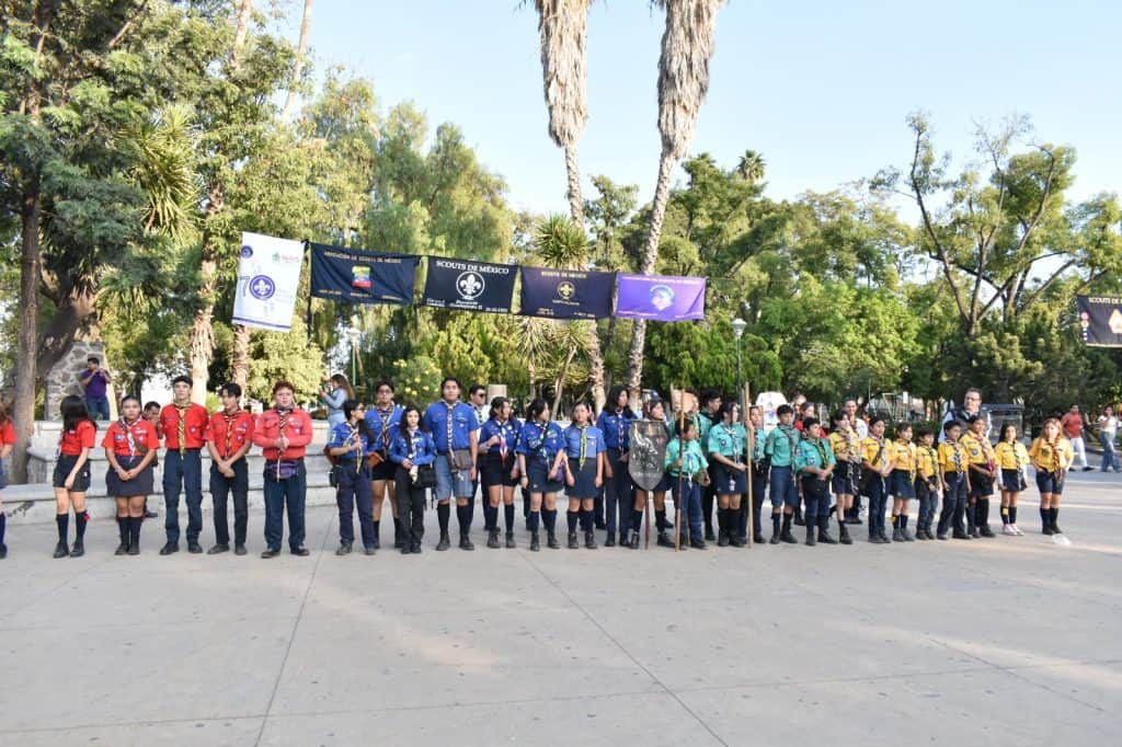 Niños scouts en formación al aire libre en un parque de México.