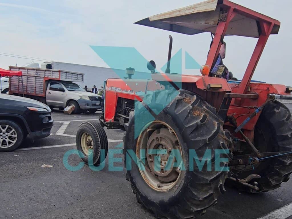 1. Tractor rojo en medio de un choque con varios autos en una carretera congestionada.