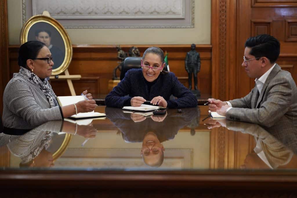1. Mujeres en una reunión de trabajo en oficina, discutiendo temas importantes con actitud profesional.