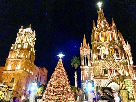 Guanajuato en Navidad: destinos para vivir la magia decembrina en familia Árbol de Navidad iluminado en plaza con catedral en background, celebración navideña en México.