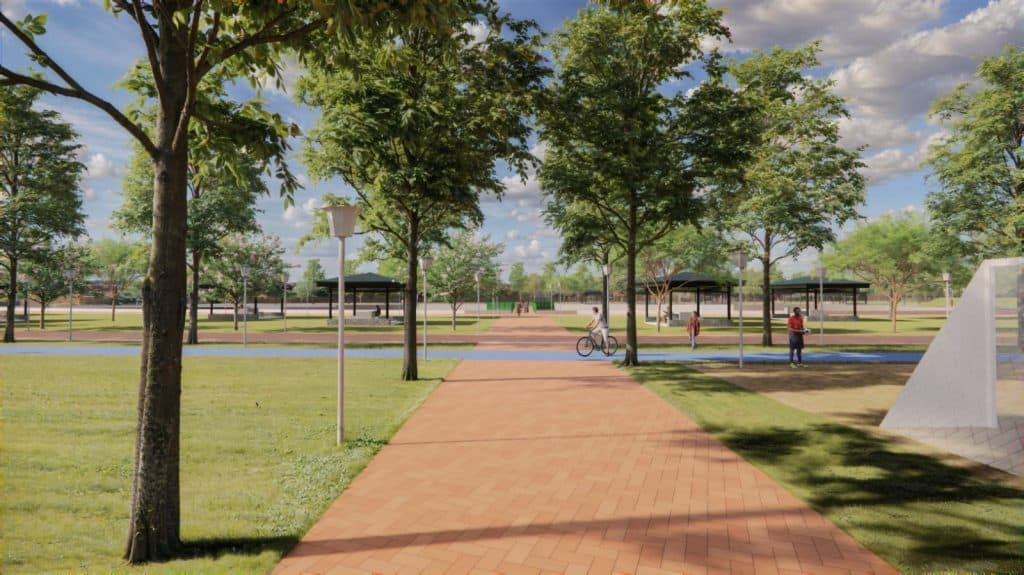 árboles en parque urbano con senderos y áreas de descanso en día soleado.