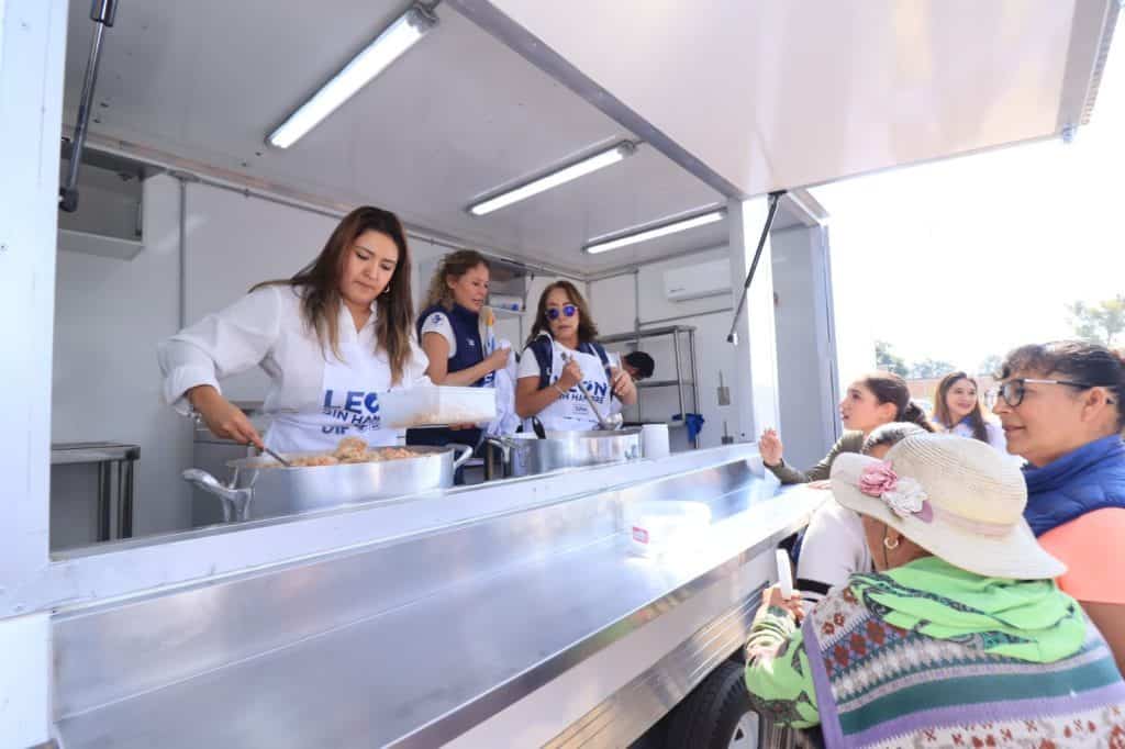 Comida tradicional en feria culinaria en México, mujeres disfrutando de un festival gastronómico en un food truck.