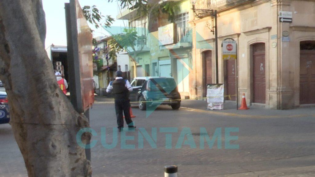 Detectives controlando una escena en la calle con marcas de peligro y conos de tráfico.