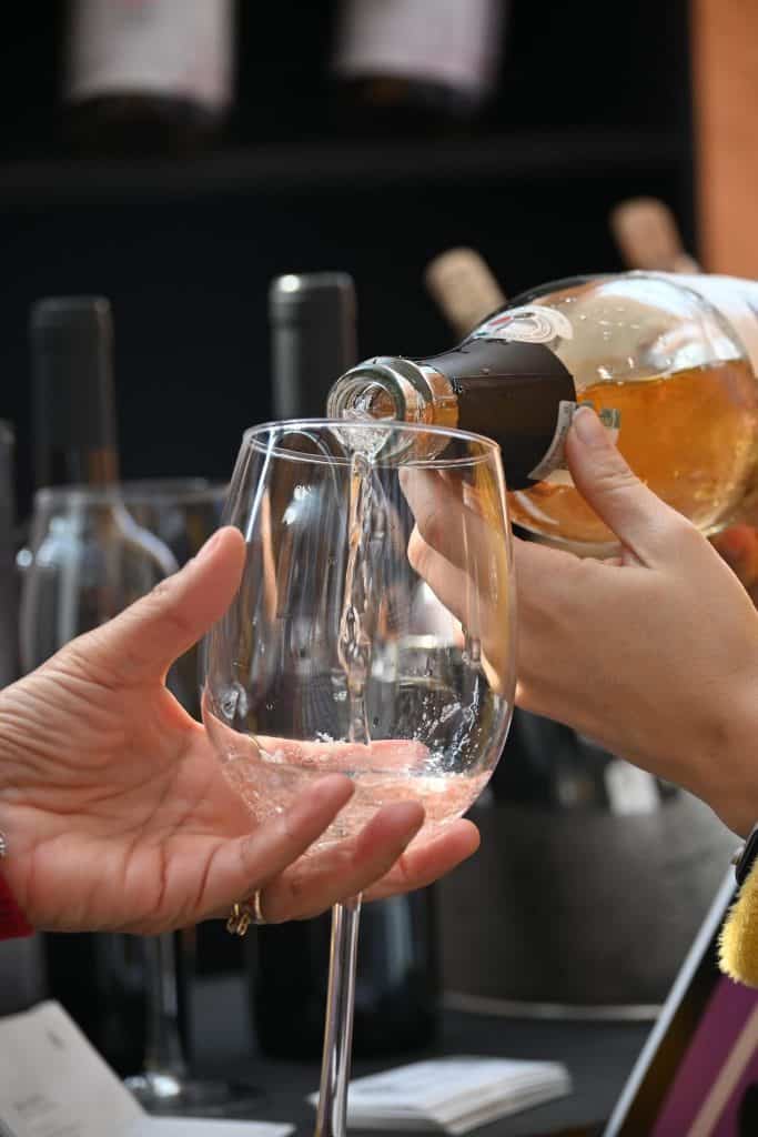 Brindis con vino espumoso en copa de cristal, celebración y momentos especiales.