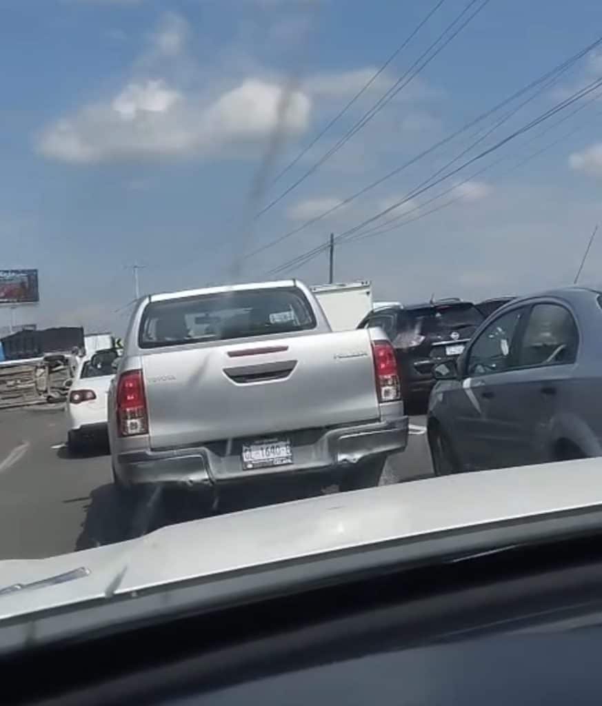 Atasco vehicular con humo en carretera, tráfico lento, accidentes de coche, emergencia, congestión de tráfico en ciudad.