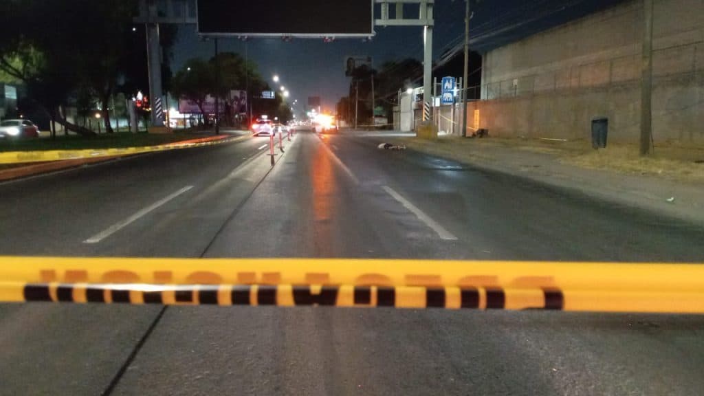 Muertes en accidente vial con cinta de seguridad en la calle.