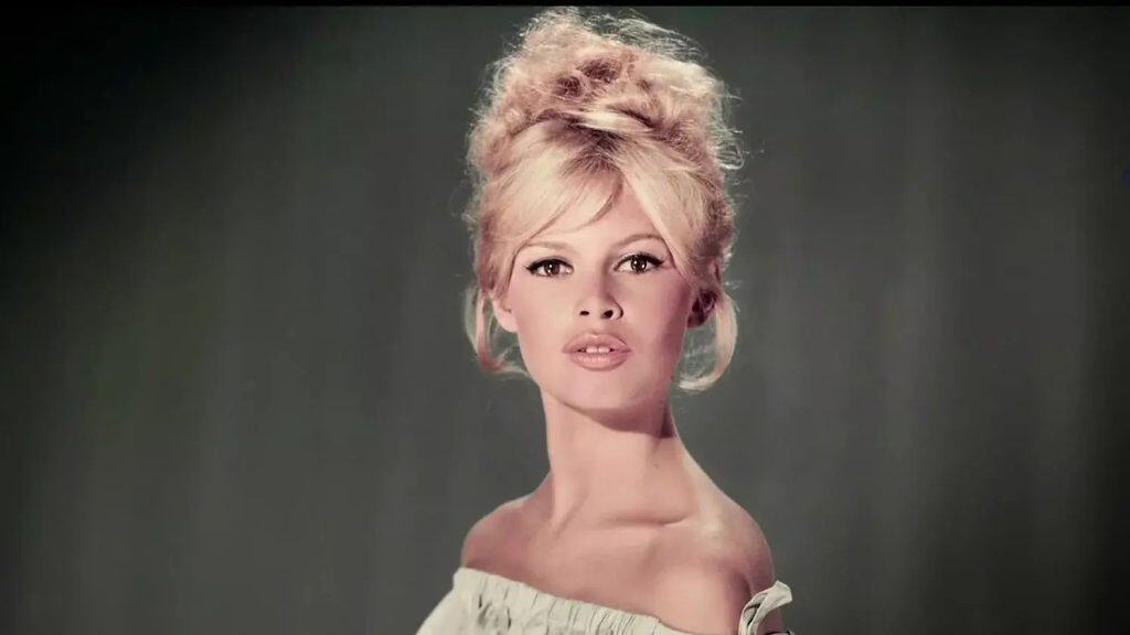 Hermosa mujer con peinado voluminoso y elegante, retrato artístico en fondo gris oscuro.