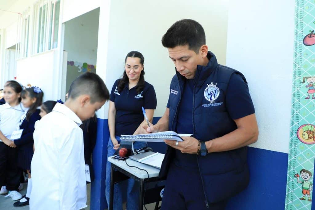 1. Supervisores de educación en plantel escolar registrando datos de estudiantes.