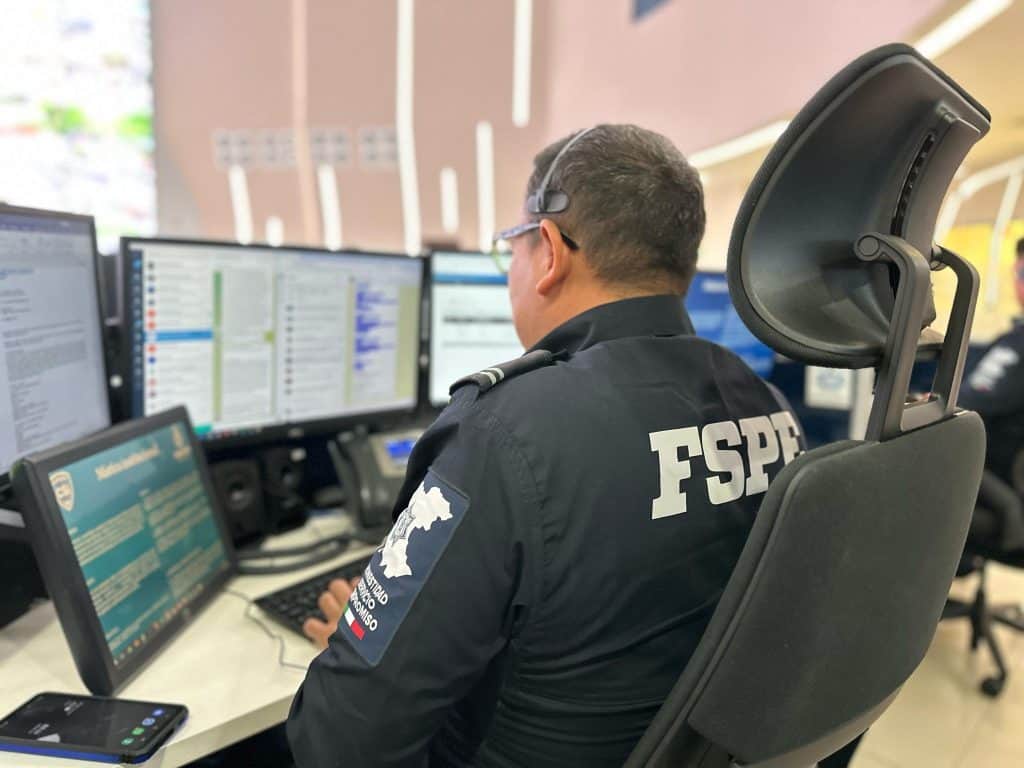 1. Agente de seguridad monitoreando en centro de mando con múltiples pantallas de control.