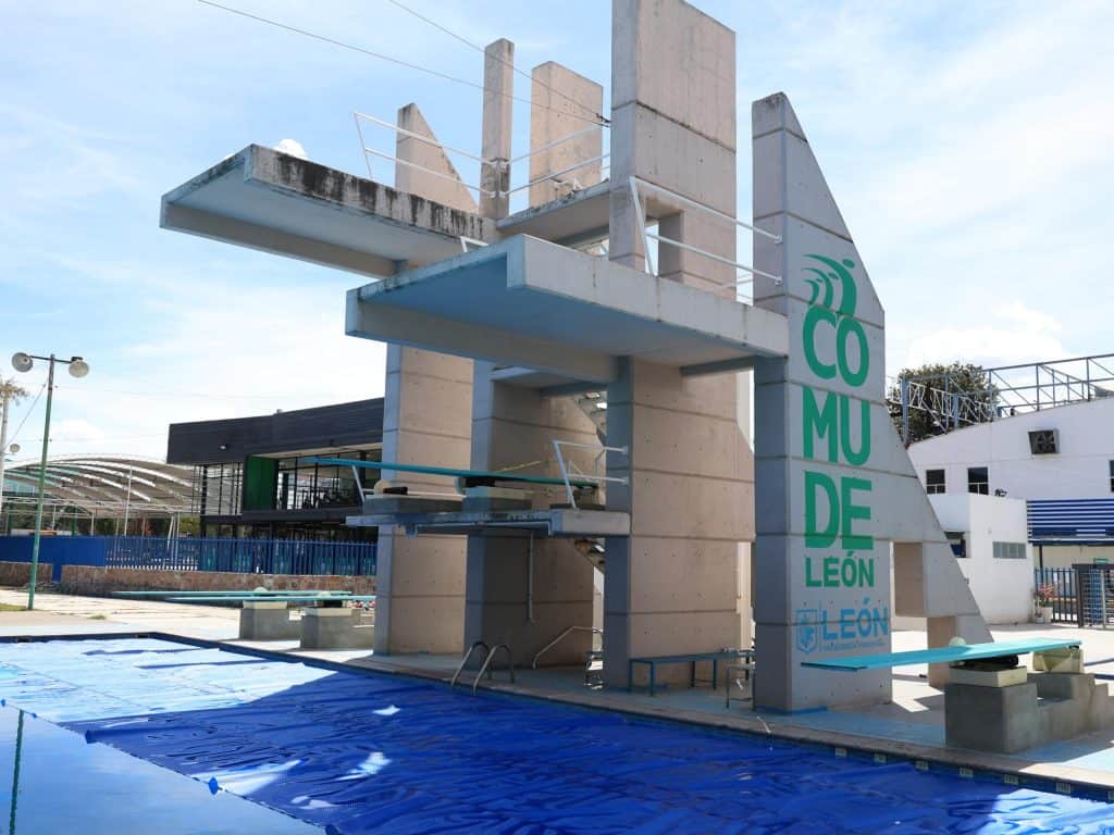 Escuela de natación en el parque de la comunidad de León, Monterrey, con área de trampolines y señalización oficial.