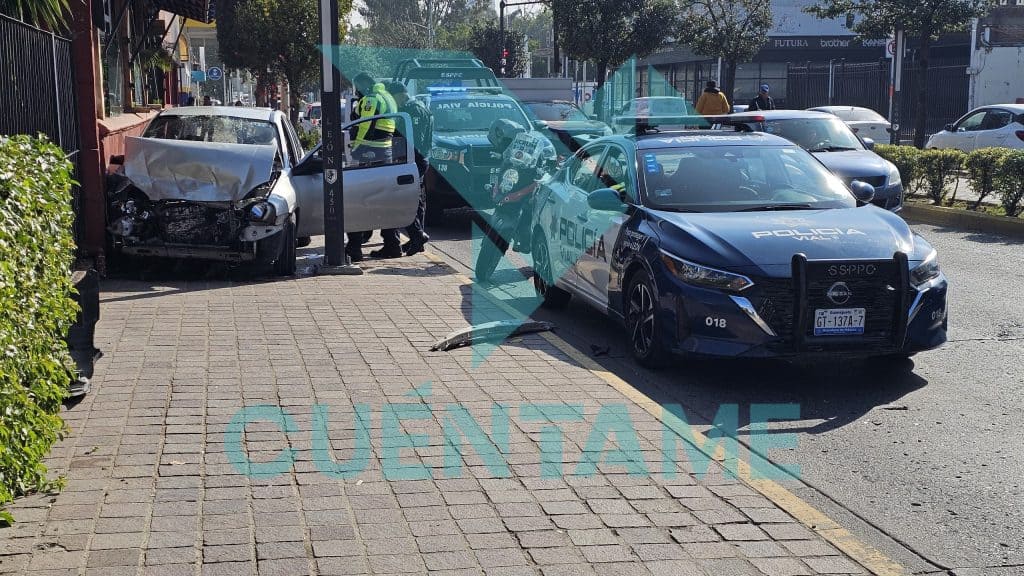 Conductor presuntamente ebrio provoca fuerte accidente en Calzada de los Héroes Choque entre un auto y una patrulla en la calle, policías y paramédicos atendiendo la escena.