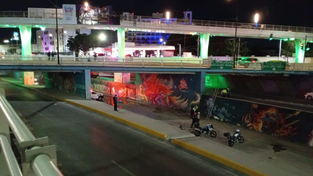Colorido arte urbano graffiti en muro de puente en ciudad de noche.