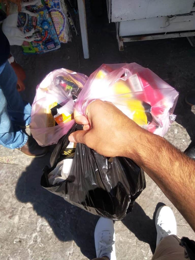 Cargando bolsas de supermercado con compras en un mercado al aire libre.