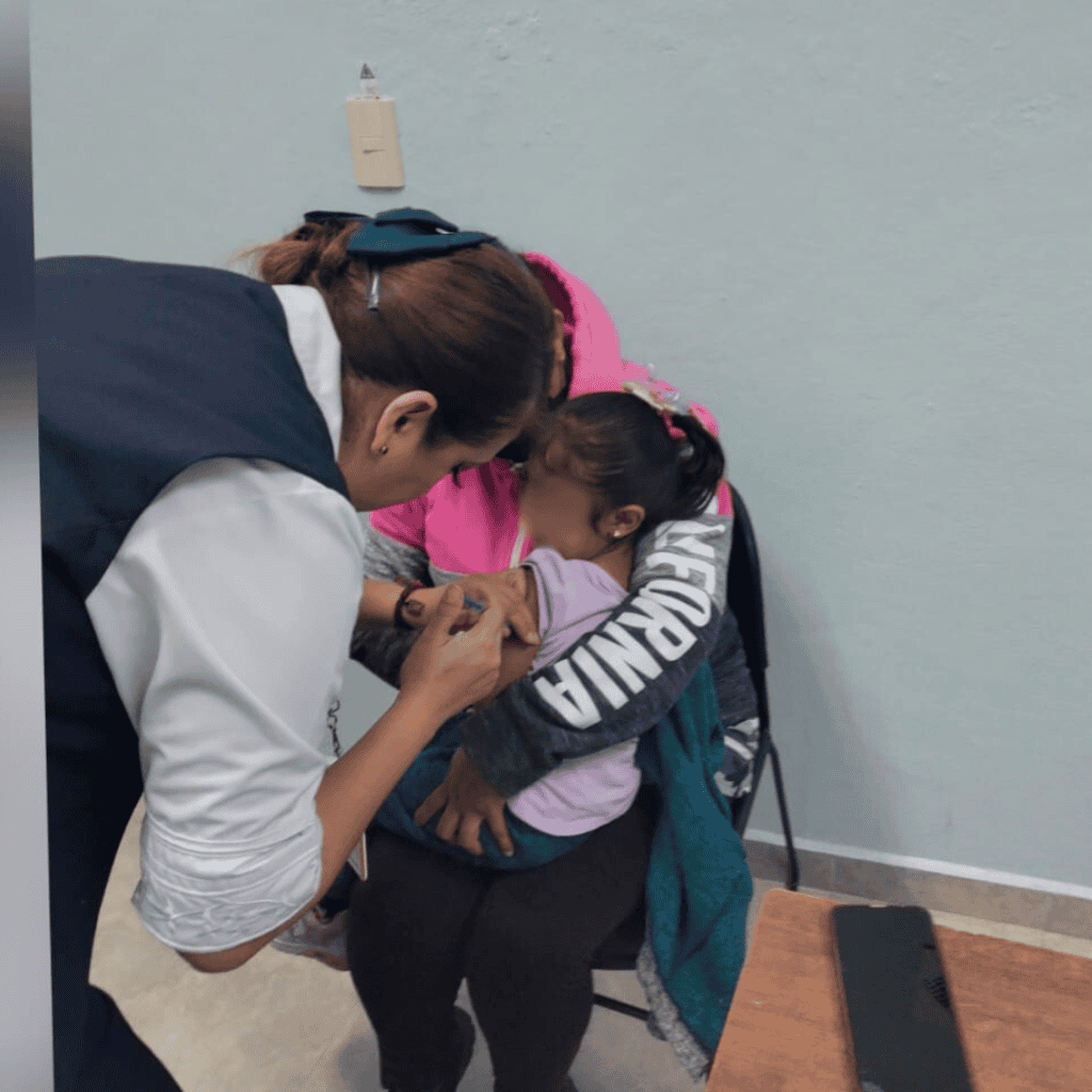 Vacuna infantil siendo aplicada por una profesional en una clínica médica.