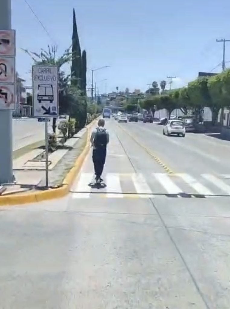 Scooters y patinetas invaden el carril de la Oruga sin sanción; urgen a legislar para proteger el transporte público en León Niño caminando en cruce peatonal en ciudad, tránsito y señalética vial.