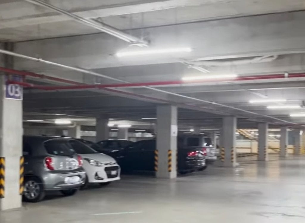 Autos estacionados en sótano de estacionamiento subterráneo.