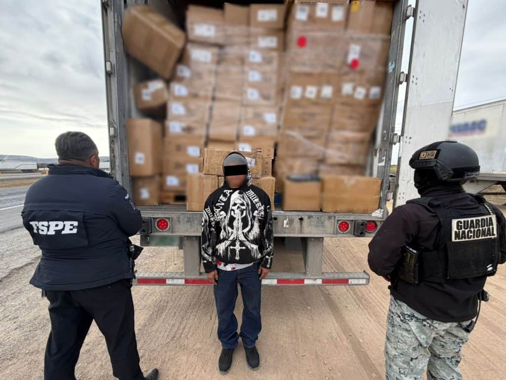 Supuesta detención de contrabando de mercancía en la frontera, agentes de seguridad revisan un vehículo con carga.