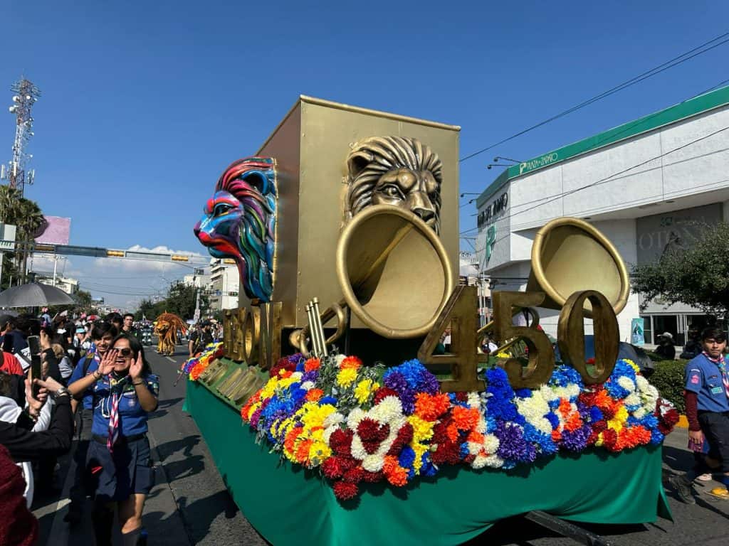 Colorido carro alegórico de 50 años en desfile cultural con reconocimiento a la historia.